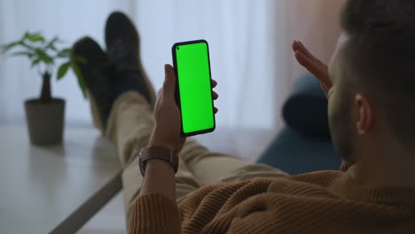 man-is-calling-by-video-chat-in-smartphone-from-home-or-office-at-break-time-green-screen-on-gadget-app-for-online-communicating-and-chatting